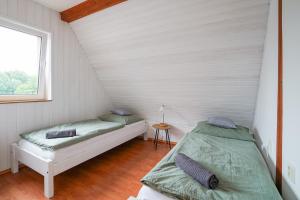two beds in a white room with a window at Chata Roudenka in Roudno