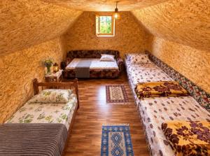 a room with three beds in a stone walled room at Katun Lanista-Kolibe Bogavac in Mojkovac