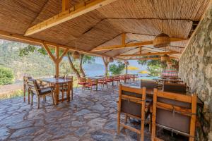 ein Restaurant mit Tischen und Stühlen und einer Steinmauer in der Unterkunft Flavia Hotel in Kızılcakaya