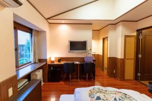 a room with a bed and a desk with a television at 灯ノ環tomonowa in Mitsuwa