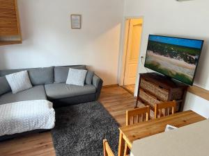 a living room with a couch and a flat screen tv at Johanna Apartman in Harkány