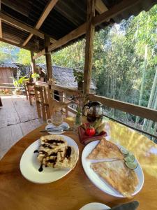 a table with two plates of food on it at Red Dao Homestay and Entire bungalow in Tả Van