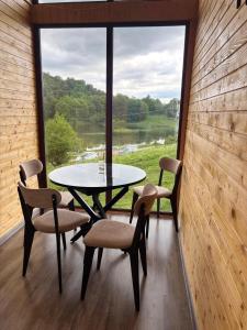 a table and chairs in a room with a large window at Lake Tsover in Dsegh