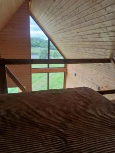 a bed in a room with a large window at Lake Tsover in Dsegh