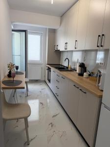a kitchen with white cabinets and a table and a tableablish at Elegant & cozy NeSt in Chiajna