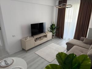 a living room with a flat screen tv on a cabinet at Elegant & cozy NeSt in Chiajna