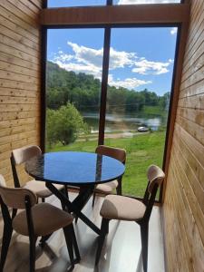 a table and chairs in a room with a large window at Lake Tsover in Dsegh