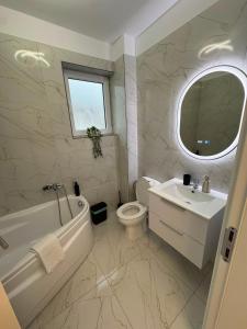 a bathroom with a tub and a toilet and a sink at Elegant & cozy NeSt in Chiajna +12 photos