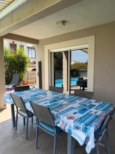 a table and chairs on a patio with a view of a pool at Location Vias in Vias