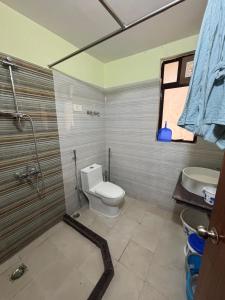 a bathroom with a toilet and a sink at The Humble Abode in kolkata +5 photos