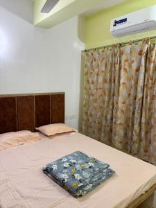 a bedroom with a bed with a blanket on it at The Humble Abode in kolkata