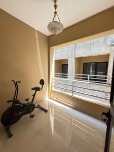 a room with a gym with a treadmill and a window at The Humble Abode in kolkata