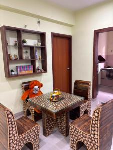 a teddy bear sitting on a table in a room at The Humble Abode in kolkata