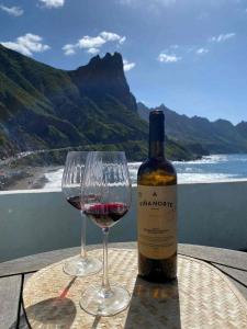 a bottle of wine and a glass on a table at Ocean front La Maresia Holiday 2 Apartments in Taganana +12 photos