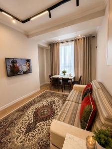 a living room with a couch and a table at Lux Residence 3 in Osh