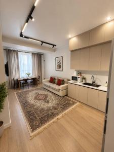 a kitchen and living room with a couch and a table at Lux Residence 3 in Osh
