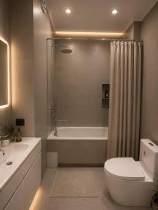 a bathroom with a tub and a toilet and a shower at Lux Residence 3 in Osh