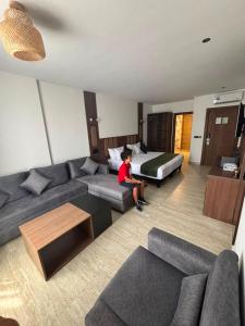 a boy sitting on a couch in a living room at Hôtel City Center in Nador