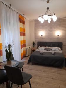 a bedroom with a bed and a table with chairs at Zöld Sziget Apartmanlakás in Eger