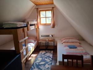 a attic room with two bunk beds and a window at Chatka pod jaskyňou in Malužiná