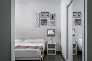 a white bedroom with a bed and a mirror at Estival Cristina in Pas de la Casa +18 photos