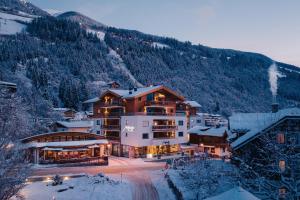 a large building in the snow with a mountain at Venediger Lodge in Neukirchen am Großvenediger