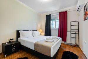 a bedroom with a large bed and red curtains at Pallantides Residence in Pallini