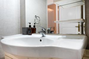 a bathroom with a white sink and a mirror at Pallantides Residence in Pallini +32 photos