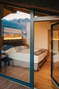 a bed in a room with a glass window at Venediger Lodge in Neukirchen am Großvenediger +48 photos