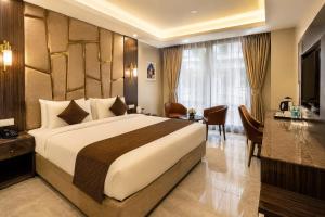 a hotel room with a large bed and a desk at Hotel Aviora Plaza By Almati Group Near IGI Delhi Airport With - Free Airport Pickup in New Delhi