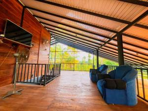 a living room with two blue chairs on a porch at Senaro Villa in Sigiriya