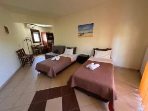 a hotel room with two beds and a table at Morfili Villa in Limenaria