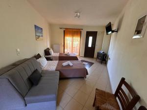 a living room with two beds and a couch at Morfili Villa in Limenaria