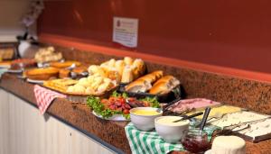 ein Buffet mit Brot und anderen Speisen an einer Theke in der Unterkunft Domus Hotel Cidade Nobre - Ipatinga in Ipatinga + 40 Fotos