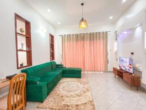a living room with a green couch and a tv at Ssentongo Properties Limited in Kampala