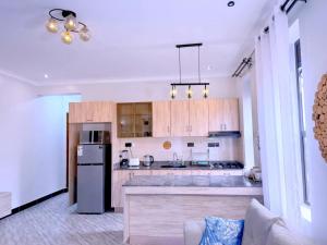 a kitchen with wooden cabinets and a refrigerator at Ssentongo Properties Limited in Kampala