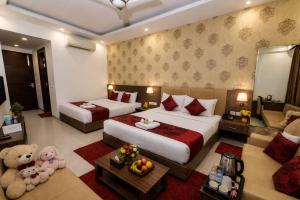 a hotel room with two beds and a living room at Hotel Aviora Plaza By Almati Group Near IGI Delhi Airport With - Free Airport Pickup in New Delhi