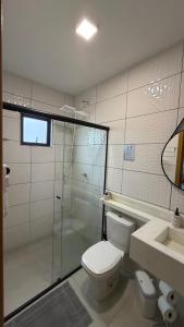 a bathroom with a toilet and a shower and a sink at Studios Carambeí in Carambeí +27 photos