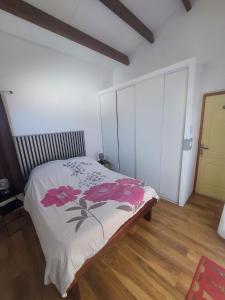 a bedroom with a bed with pink flowers on it at L'Oreiller du Maïdo in Saint-Paul