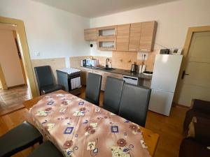 a kitchen with a table and chairs and a kitchen with a refrigerator at Chalupa u Tomáša in Lúčky
