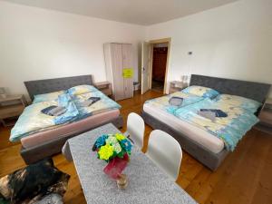 a room with two beds and two tables with flowers on them at Chalupa u Tomáša in Lúčky