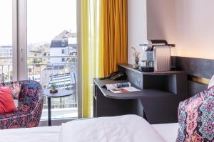 ein Hotelzimmer mit Bett, Schreibtisch und Fenster in der Unterkunft Lifestyle Hotel Sedartis Lake Zurich in Thalwil