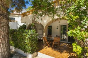 a patio with a table and chairs under an archway at MR Hotelet de la Raconà & Apartments in Denia