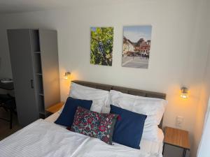 a bedroom with a bed with blue and white pillows at Natali Apartmanház in Eger