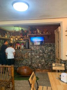 two people standing in a room with a stone wall at Cactus Hotel in Kobuleti