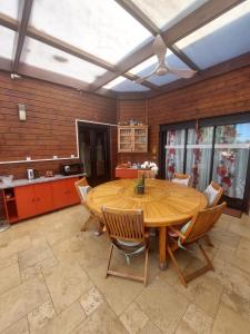 a large kitchen with a wooden table and chairs at L'Oreiller du Maïdo in Saint-Paul