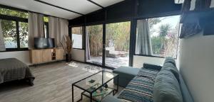 a living room with a blue couch and large windows at Naturarte Guesthouse in Terrasini