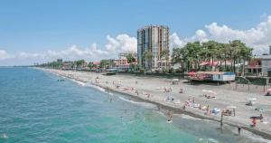 a beach with a bunch of people on the water at Cactus Hotel in Kobuleti
