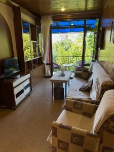 a living room with two beds and a television at Ios Guest House 2 in Kobuleti