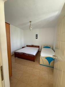 two beds in a room with a door open at Villa Balliu in Pogradec